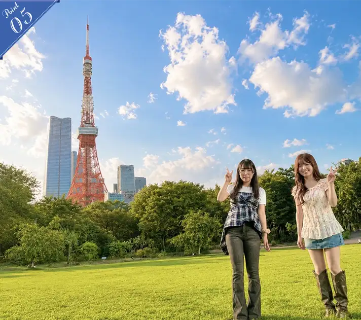 緑が広がるプリンス芝公園で東京タワーを背景にピースサインをする2人の女性
