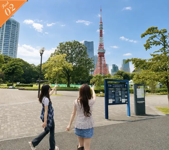 芝公園の遊歩道から東京タワーを指差して喜ぶ後ろ姿の2人の女性