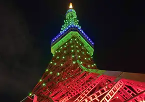 先端部が赤と緑にライトアップされた東京タワーのクローズアップ